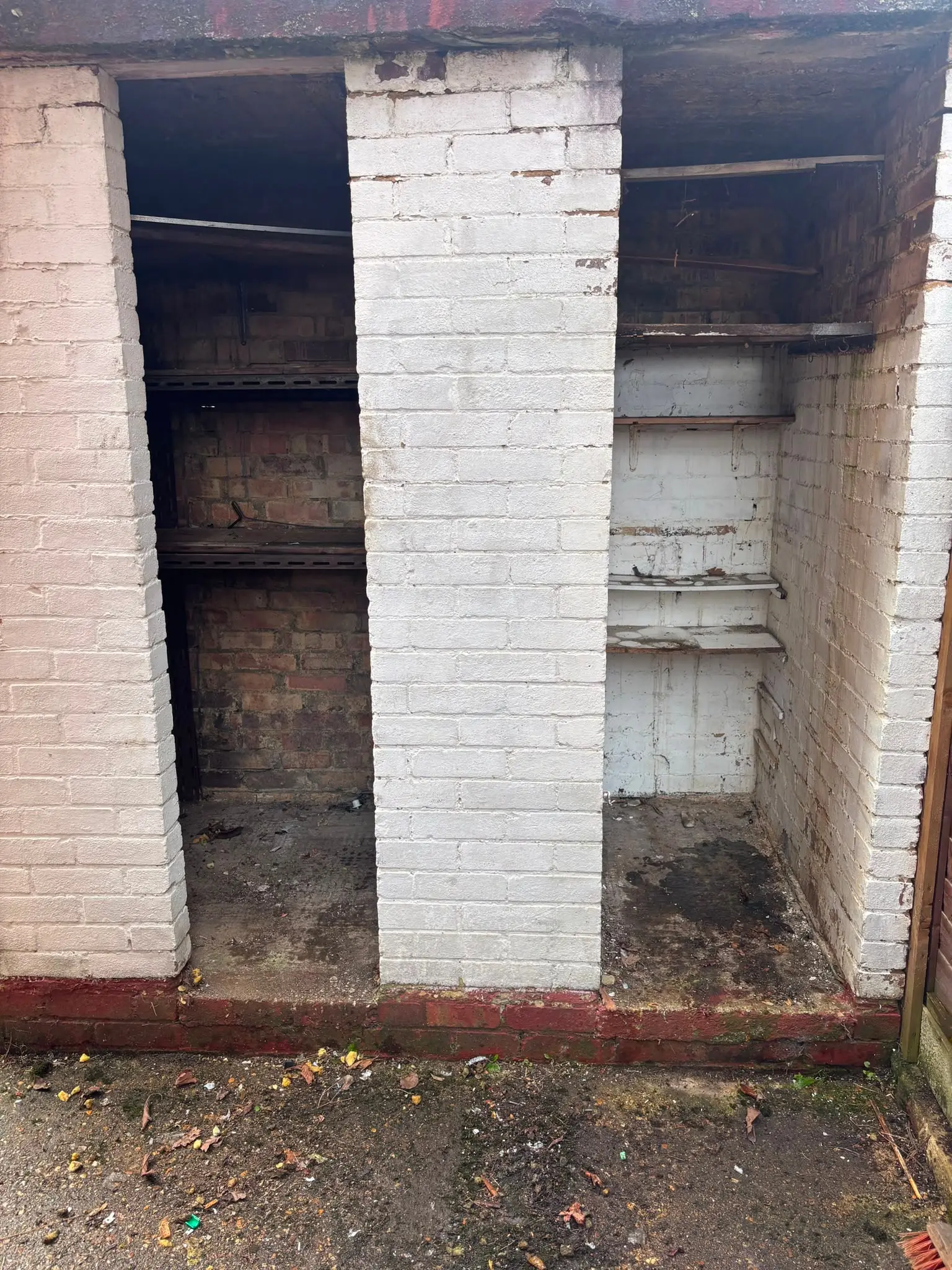 The same garage or outbuilding cleared, with the floor and storage space visible.