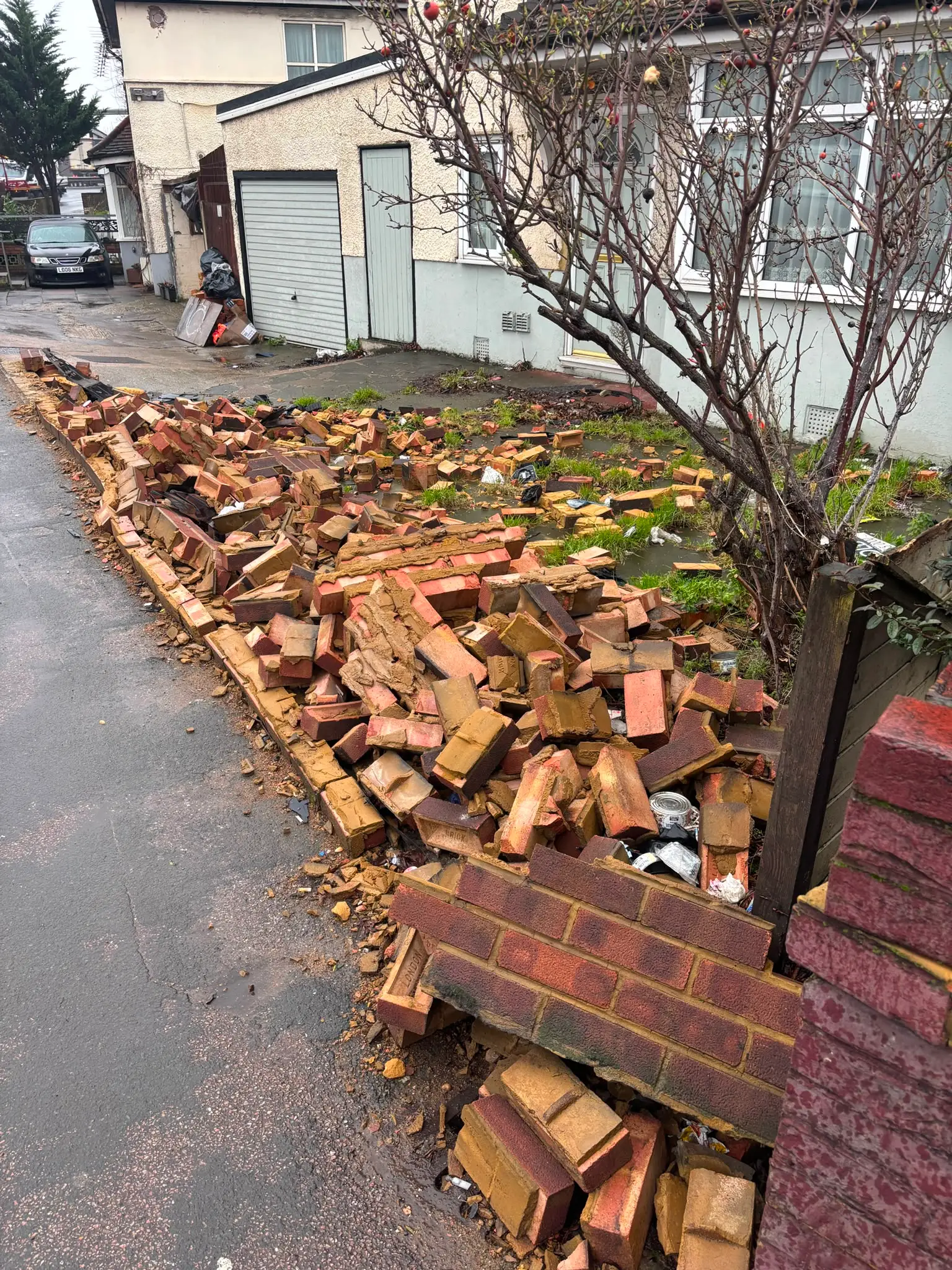 Bricks and renovation materials collected beside a residential property.