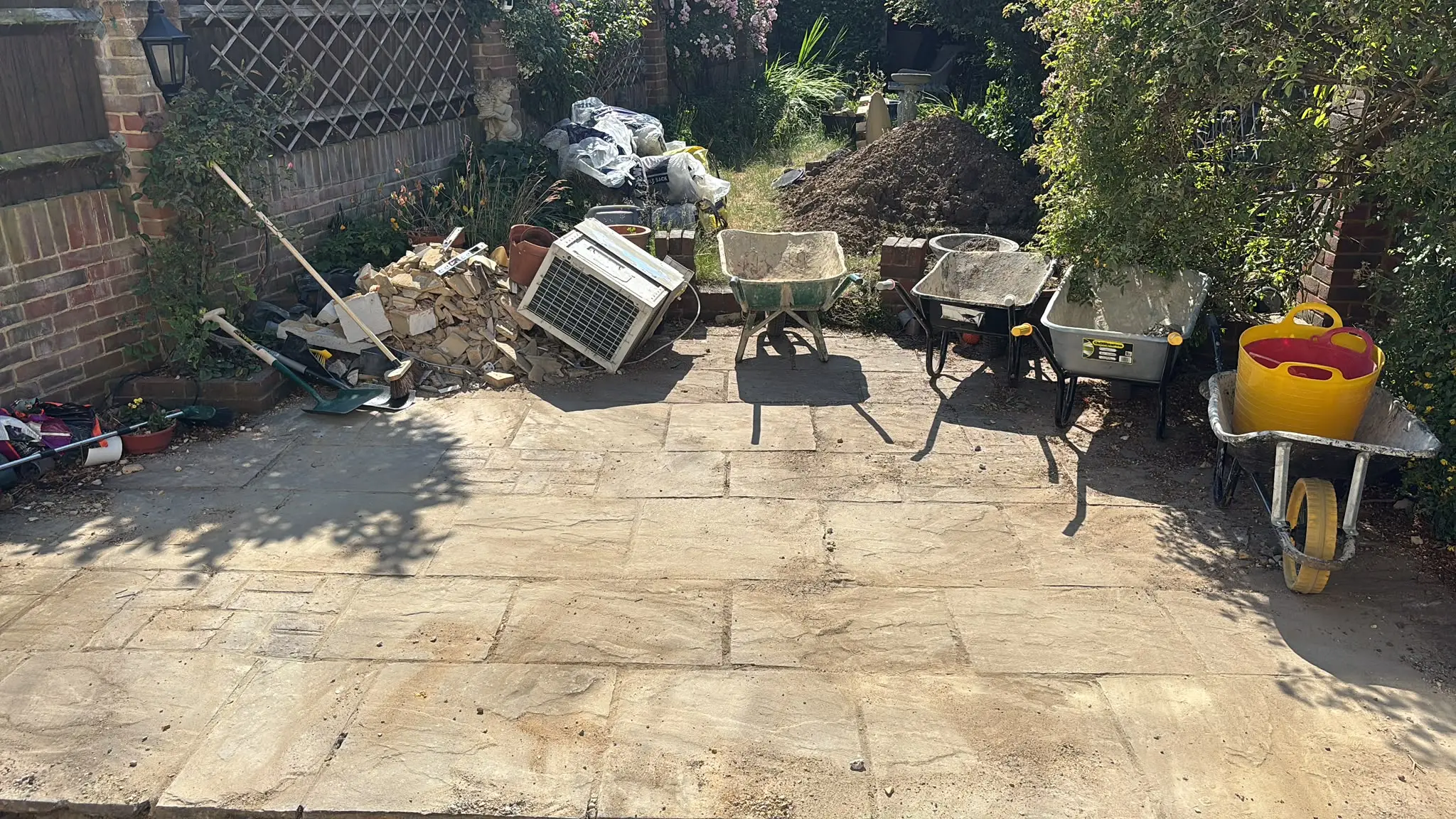 Garden renovation area with rubble and materials gathered for clearance.