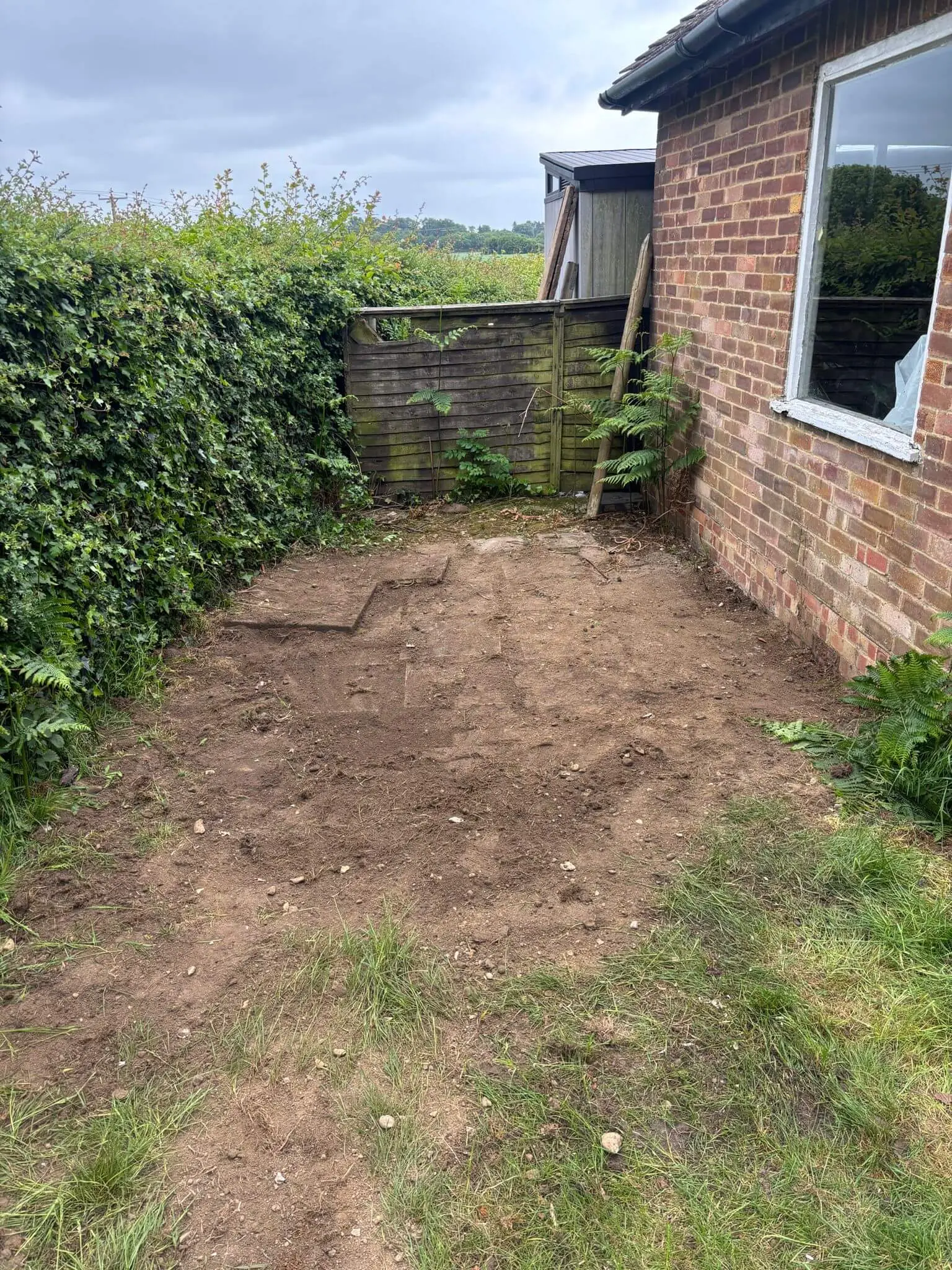 Garden area after the mound of soil, turf and excavation waste has been cleared.